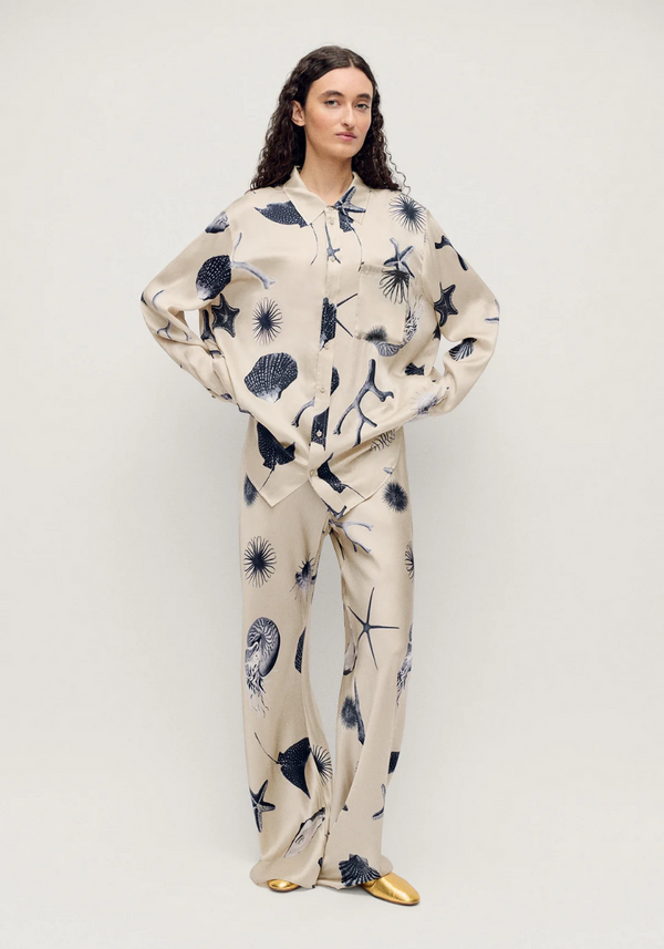 Woman wearing a floral pajama set on a plain background