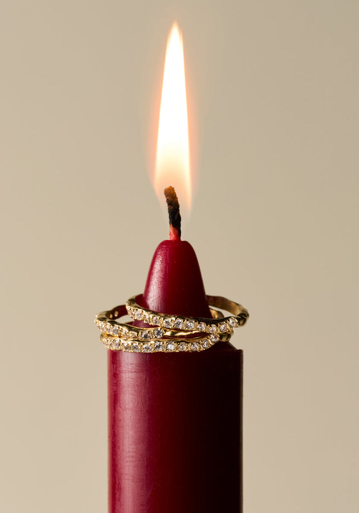 Three Agapée Clara Rings stacked on a red candle