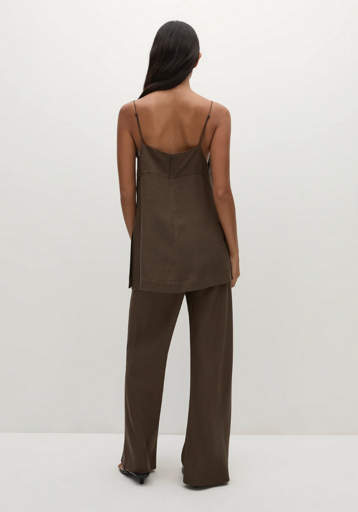 Person wearing a brown slip dress with wide-leg pants on a white background