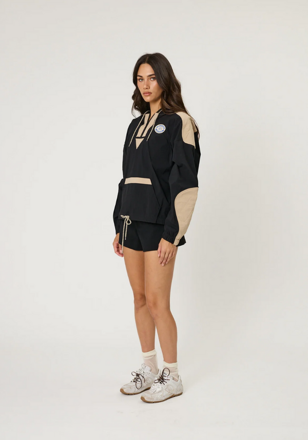 Woman wearing a black and beige outfit with a white background