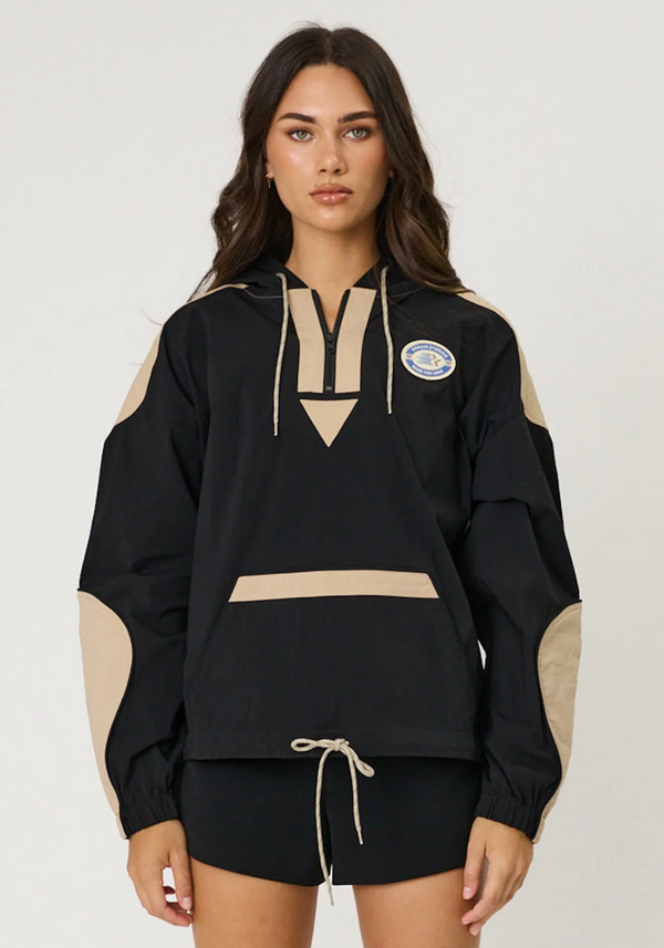 Woman wearing a black and beige outfit with a logo on a white background