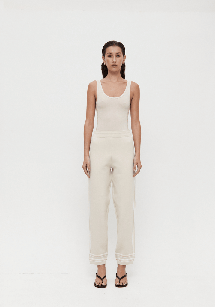 Woman wearing a white sleeveless jumpsuit on a white background