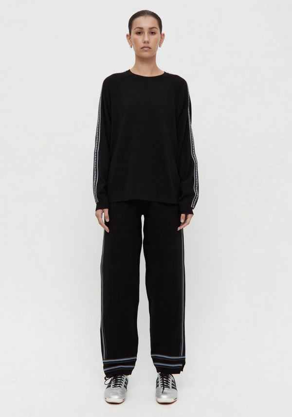 Person wearing a black outfit with white stripes on a white background