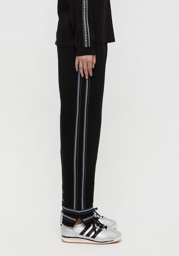 Black pants with white stripes worn by a person on a white background