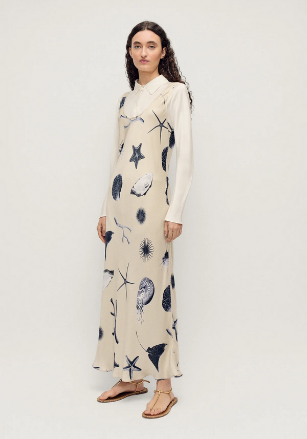 Woman wearing a long dress with starfish pattern on a white background - Scoop Neck beige dress